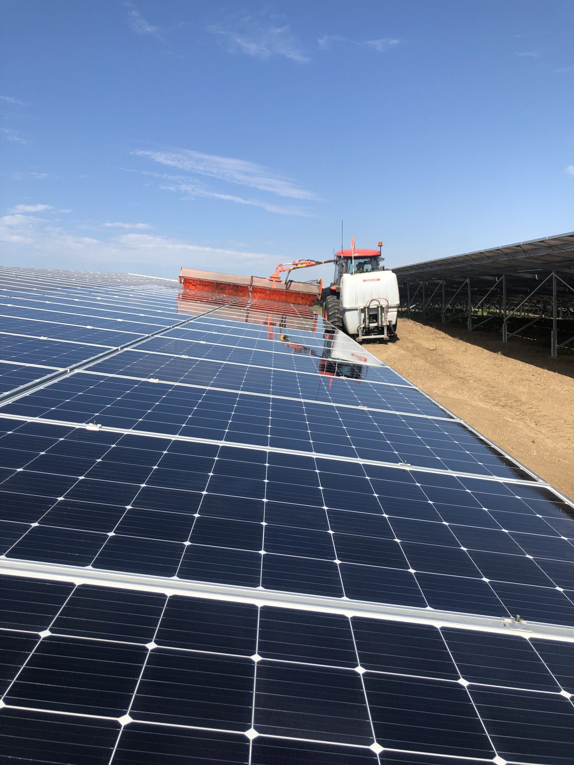 A solar farm cleaning equipment cleaning an entire spread of solar glass panels.